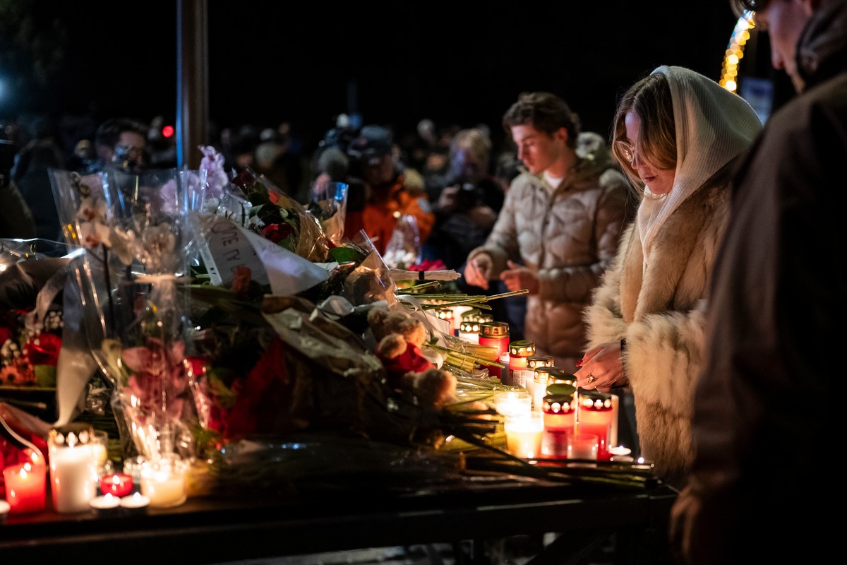 Mourners gather to lay down flowers and light candles to remember the victims of the fire at the "Le Constellation" bar and lounge leaving people dead and injured, during New Year's cel ...