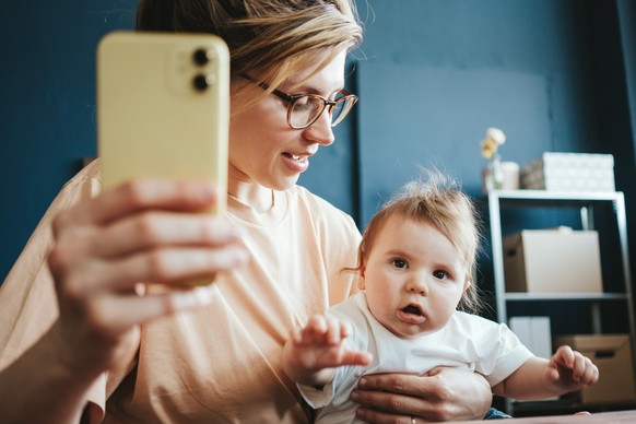 Mutter hält ihr Baby an einem Pult.