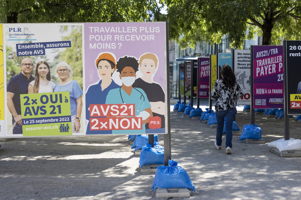 Une personne passe entre les affiches des partis politiques et des associations donnant leurs mots d'ordre pour les votations federales du 25 septembre, ce lundi 19 septembre 2022 a Geneve. Les c ...