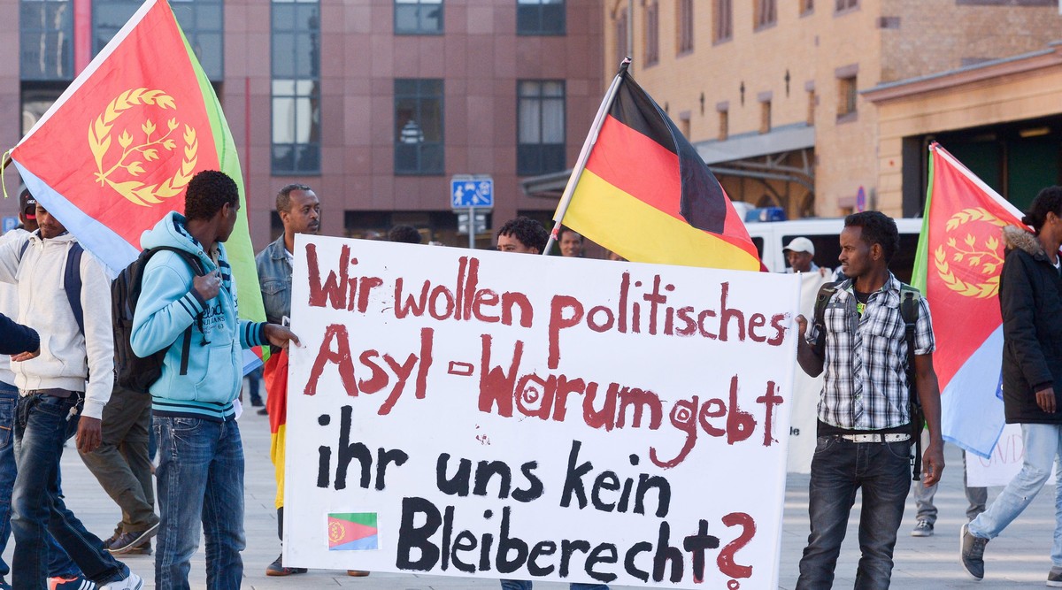 epa04960367 Migrants from Eritrea demonstrate with a banner that reads: "Wir wollen politisches Asyl - Warum gebt ihr uns kein Bleiberecht?" (lt: We want political asylum - why give us no ri ...