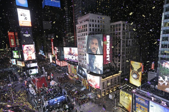 Confetti flies over Times Square during the New Year&#039;s celebration in New York, Sunday, Dec. 31, 2017. New Yorkers, celebrity entertainers and tourists from around the world are packing into a fr ...