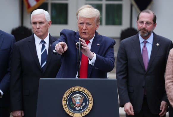 epa08293158 US President Donald J. Trump (C) gestures as he takes questions with US Vice President Mike Pence (L) and US Secretary of Health and Human Services Alex Azar (R) after declaring a national ...