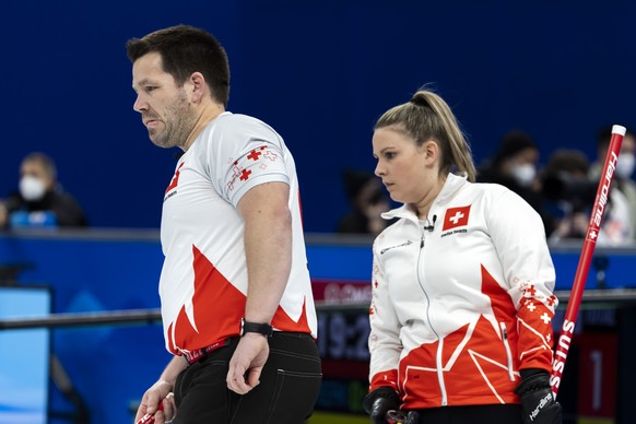 Martin Rios, left, and Jenny Perret, of Switzerland team, observe during the curling mixed doubles preliminary round game between China and Switzerland at the 2022 Olympic Winter Games in Beijing, Chi ...