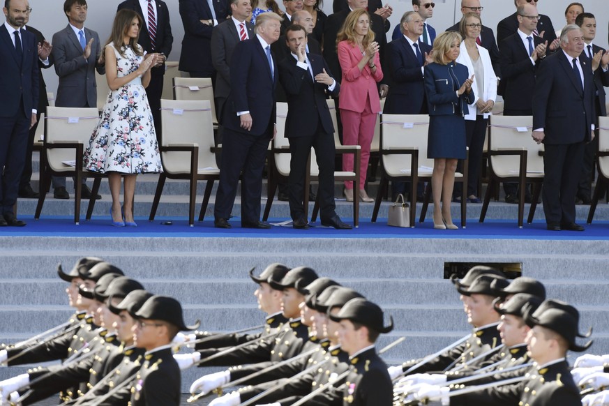 epa06087227 Military personnel march as (background, L-R) US First Lady Melania Trump, US President Donald J. Trump, French President Emmanuel Macron and French First Lady Brigitte Macron, watch the t ...