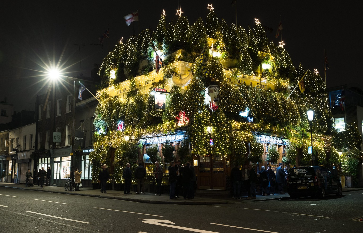 epa05678748 A popular pub in Notting Hill, The Churchill Arms, is decorated with a total of 21,000 lights and 90 Christmas trees. The pub in Kensington is famous for the festive display it puts on eac ...