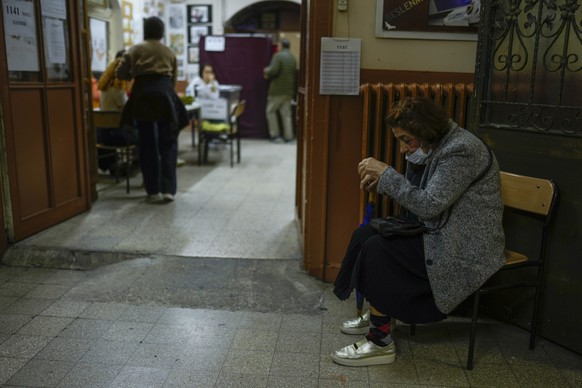 A woman waits outside a polling station in Istanbul, Turkey, Sunday, May 28, 2023. Voters in Turkey are returning to the polls to decide whether the country&#039;s longtime leader stretches his increa ...