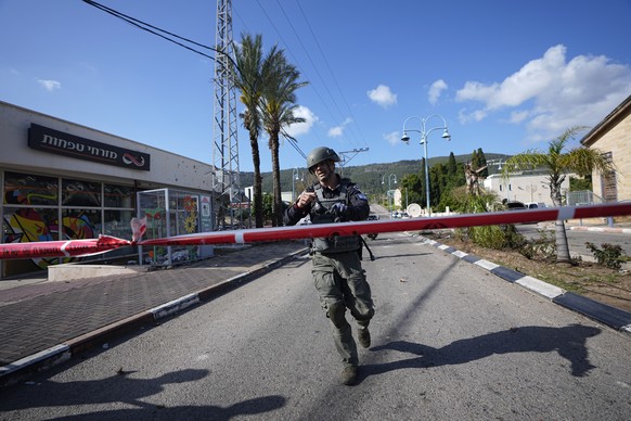 An Israeli police officer runs to remove remains of an intercepted rocket fired from Lebanon in Shlomi, northern Israel Thursday, April 6, 2023. Israeli air defenses intercepted a rocket fired from Le ...