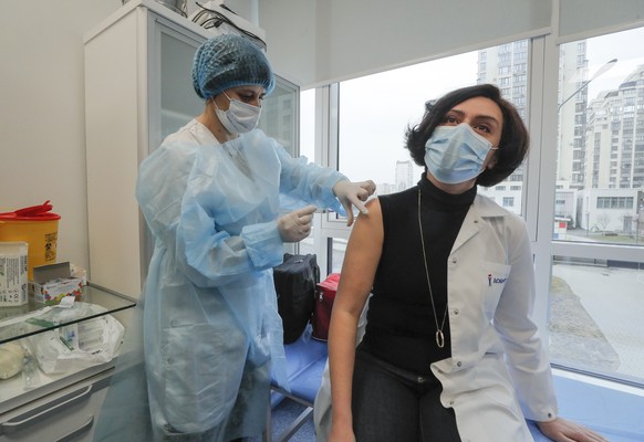epa09053679 A medical worker receives an injection with the AstraZeneca (Covishield) vaccine in Kiev, Ukraine, 05 March 2021. The mobile medical team of the Ministry of Health of Ukraine publicly vacc ...