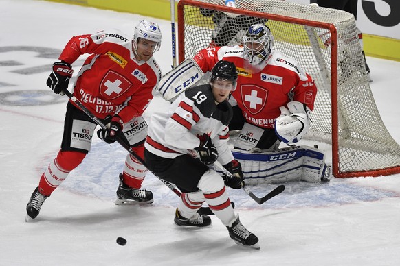 Switzerland&#039;s goalkeeper Tobias Stephan, right, and Joel Genazzi, left, fight for the puck against Canada&#039;s Brandon Buck during the Ice Hockey Deutschland Cup at the Curt-Frenzel-Eisstadion  ...