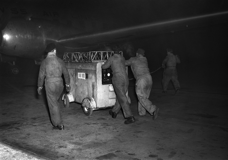 Die etwas andere Weihnachten in der Schweiz - Christnacht am Flughafen Zuerich-Kloten, aufgenommen am 24. Dezember 1958. Ein Flugzeug muss betankt werden. (KEYSTONE/PHOTOPRESS-ARCHIV/Jules Vogt)