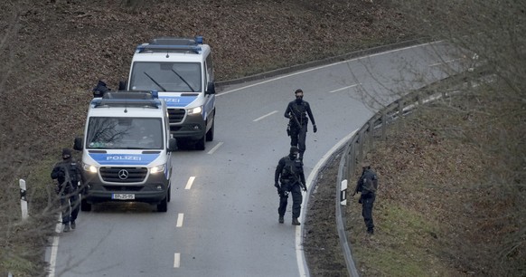 FILE - Police officers search for traces on the access road to the scene where two police officers were shot during a traffic stop near Kusel, Germany, Monday, Jan. 31, 2022. German investigators have ...