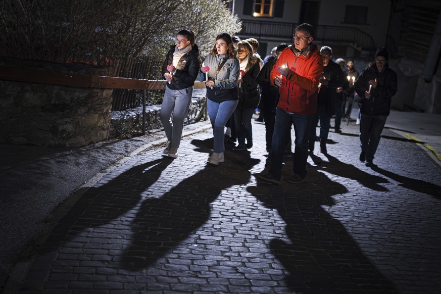 People attend a ceremony following the discovery of 5 ski tourers who had died near Tete Blanche in the Swiss alps mountains, in Vex, Switzerland, Monday, March 11, 2024. Five cross-country skiers who ...