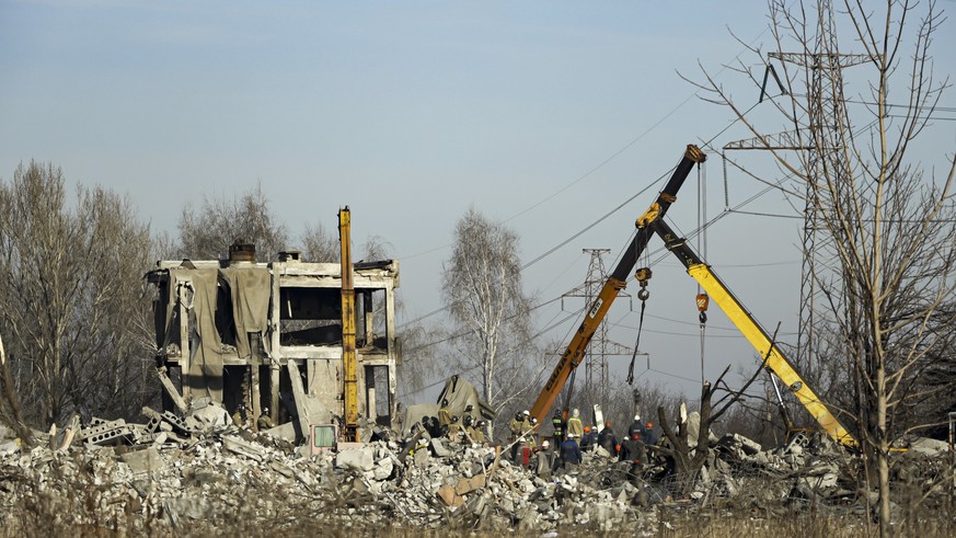 Workers clear debris after Ukrainian missile attack in Makiivka, in the Russian-controlled Donetsk region, eastern Ukraine, Tuesday, January 3, 2023. Russia's defense ministry says 63 of its soldiers are…