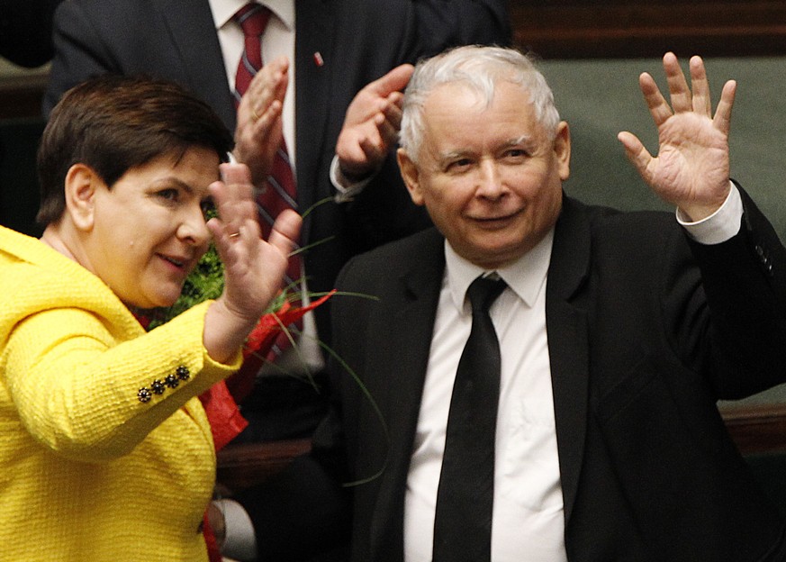 Jaroslaw Kaczynski, the powerful leader of Poland&#039;s ruling Law and Justice party and Prime Minister Beata Szydlo wave after her government survived a vote in which the opposition was seeking to o ...