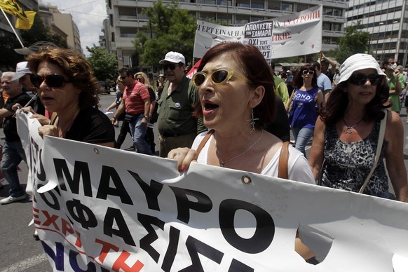 epa04249710 Striking journalists shout slogans as they march in front of the parliament building in Athens, Greece, 11 June 2014. The strike and demonstration was called by trade unions on the occasio ...