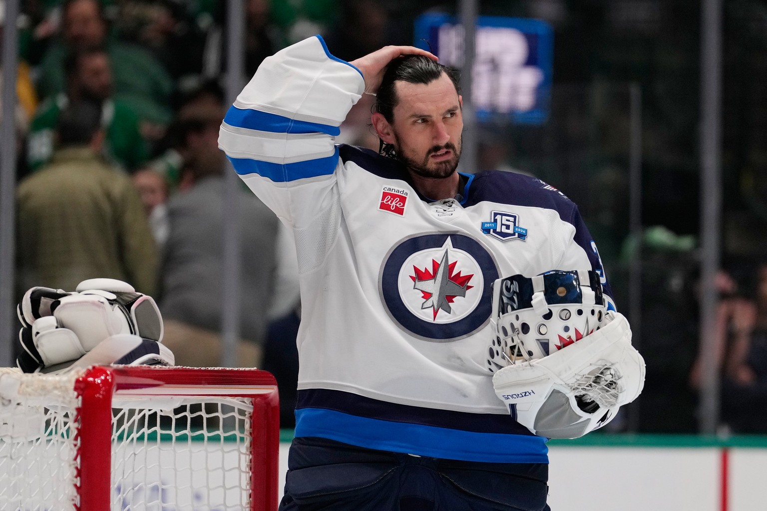 Winnipeg Jets goaltender Connor Hellebuyck stands by the net during a time out from play against the Dallas Stars in the first period of an NHL hockey game Thursday, April 2, 2026, in Dallas. (AP Phot ...