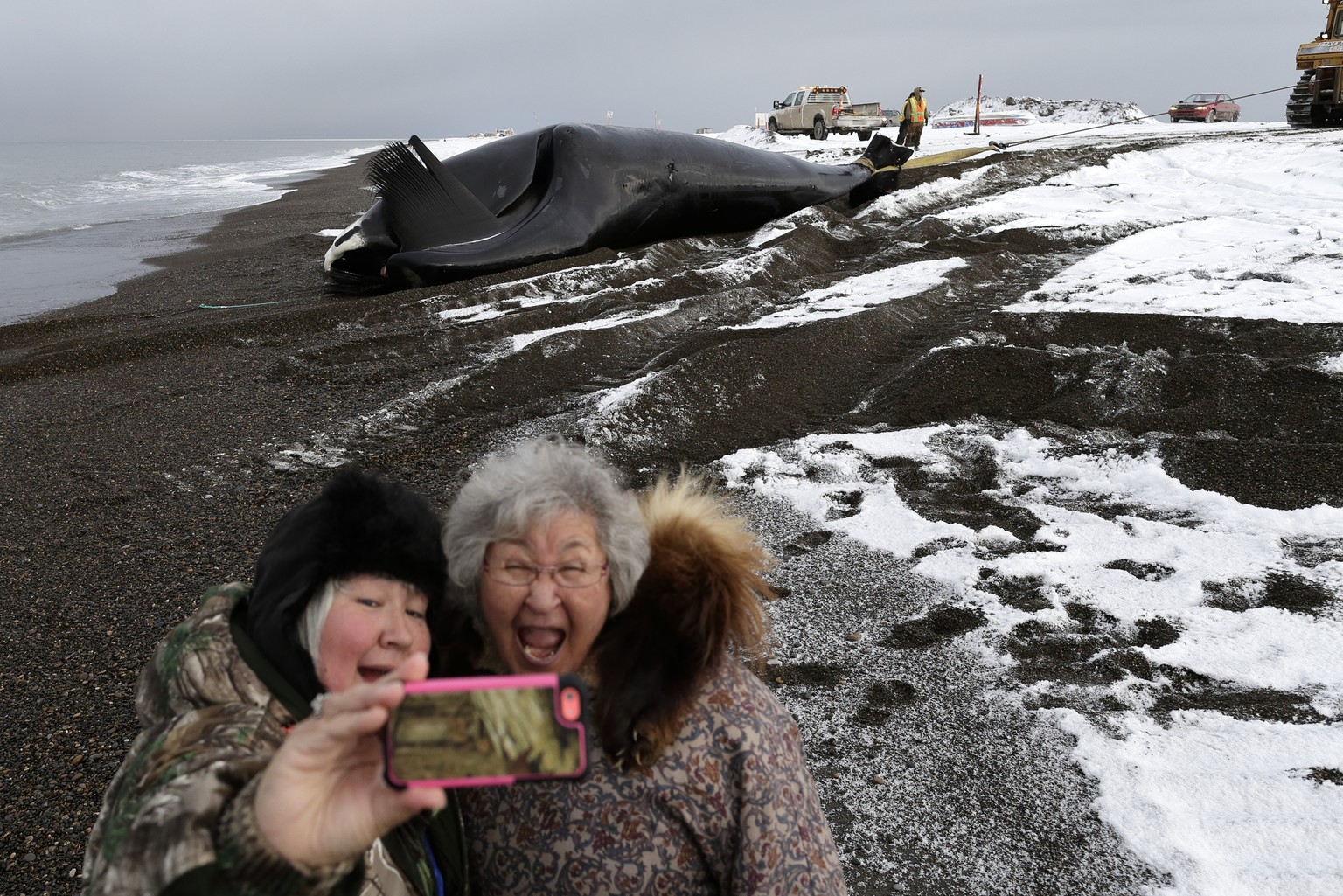 Molly Pederson (rechts) und ihre Tochter Laura Patkotak am Strand von Barrow in Alaska. Im Hintergrund ziehen Einheimische einen erlegten Grönlandwal an Land. Der Fang eines Wales ist in Barrow ein gr ...