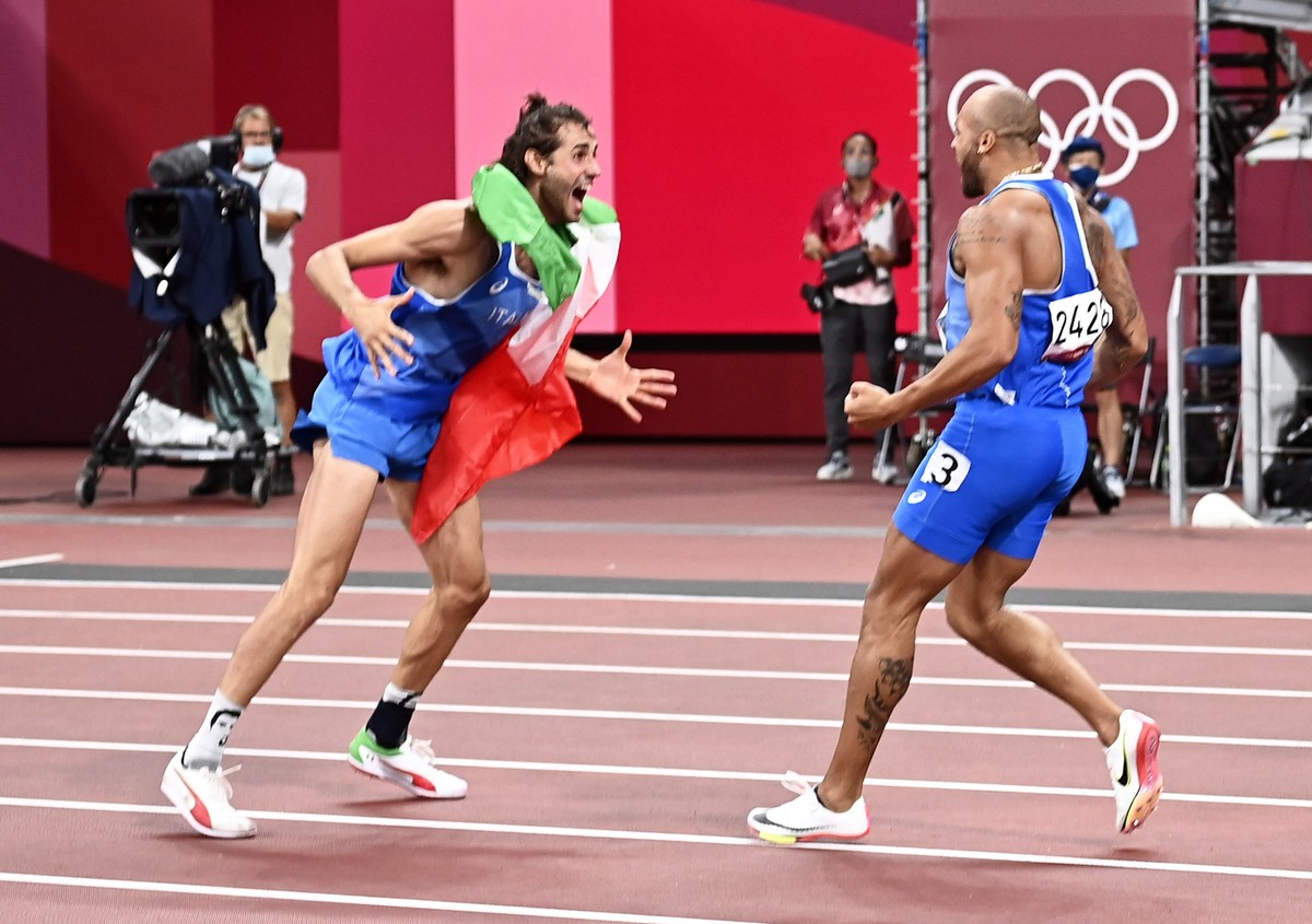 epa09385599 Gold Medalists in Men'sHigh Jump Gianmarco Tamberi of Italy (L) and gold medalist in Men's 100m Marcell Lamont Jacobs of Italy (R) celebrate during the Athletics events of the To ...
