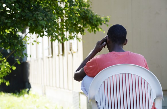 Ein Mann telefoniert im Asylzentrum Juch AOZ, aufgenommen am Mittwoch, 11. Juni 2014, in Zuerich. Seit Anfang Jahr testet das Bundesamt fuer Migration in Zuerich beschleunigte Asylverfahren. Ueber ers ...