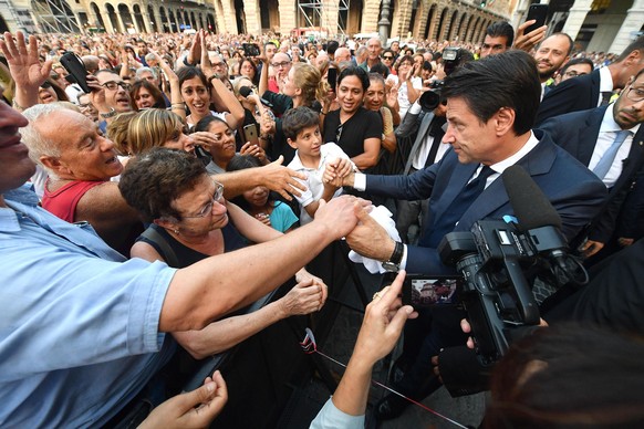 epa07020733 Italian premier Giuseppe Conte (R) speaks with citizens during the one-month anniversary of the tragic Genoa bridge collapse commemorations in Genoa, Italy, 14 September 2018. To commemora ...