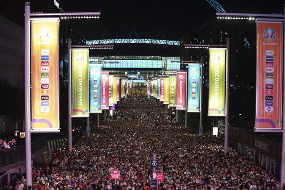 England fans celebrate outside Wembley Stadium, in London, after England qualified for the Euro 2020 final where they will face Italy on Sunday, following the Euro 2020 soccer championship semifinal m ...