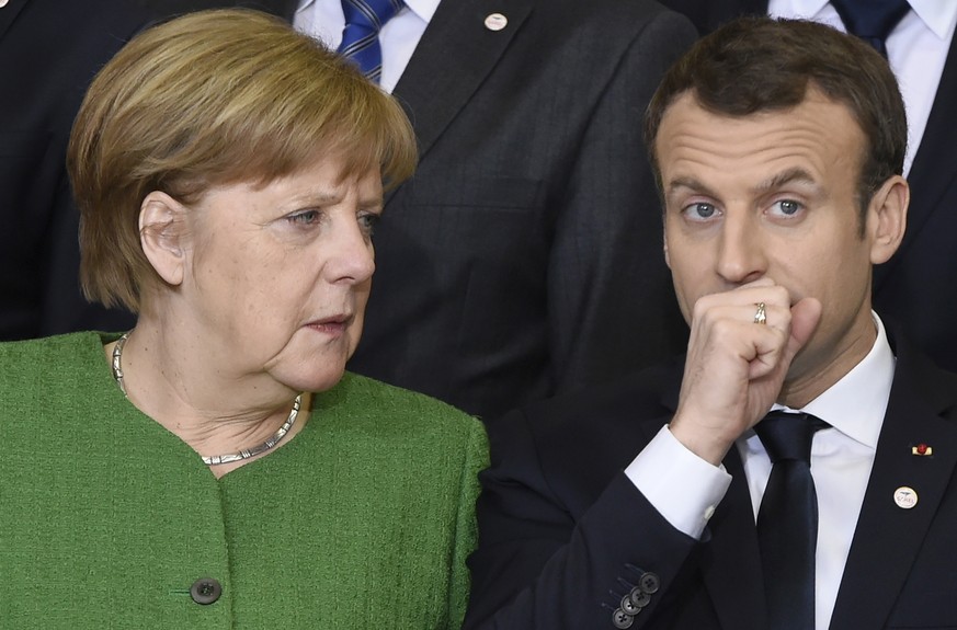 German Chancellor Angela Merkel, left, speaks with French President Emmanuel Macron during a group photo at an EU-Sahel meeting at EU headquarters in Brussels on Friday, Feb. 23, 2018. European Union  ...