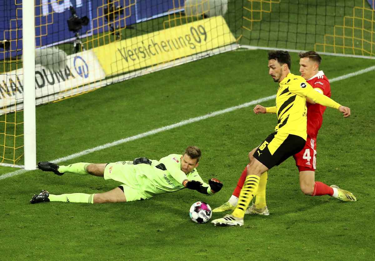 Union's goalkeeper Andreas Luthe, left, Dortmund's Mats Hummels and Union's Nico Schlotterbeck challenge for the ball during the German Bundesliga soccer match between Borussia Dortmund ...