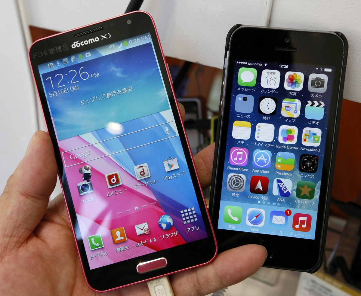 epa04208597 Samsung Electronics' smartphone Galaxy J SC-02F (L) and Apple Inc.'s iPhone 5s are seen in Tokyo, Japan, 16 May 2014. The Intellectual Property High Court said on 16 May 2014 in  ...