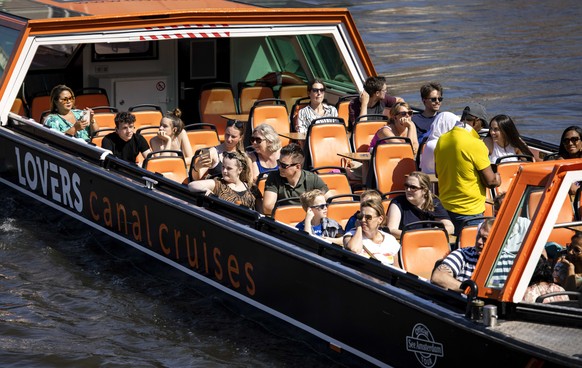 epa09352342 A tour boat on the Amstel, in Amsterdam, the Netherlands, 18 July 2021. The red color code on the European corona map has led to many Dutch people going on holiday in their own country. EP ...