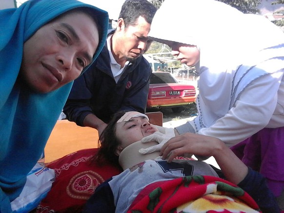 Medical officers take care of earthquake victims at Sembalun village in East Lombok, Indonesia, Sunday, July 29, 2018. A shallow, magnitude 6.4 earthquake early Sunday killed at least 10 people and in ...