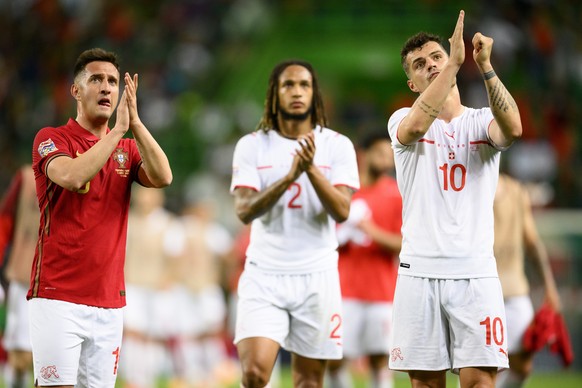 Swiss players (L-R) Mario Gavranovic, Kevin Mbabu, and Granit Xhaka applaud fans after losing the UEFA Nations League group A2 soccer match between Portugal and Switzerland at the Estadio Jose Alvalad ...