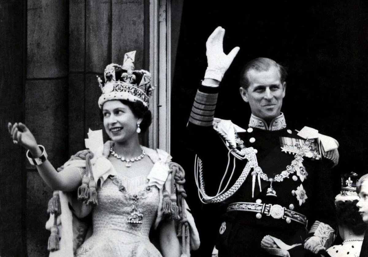 Picture dated 02 June 1953 of Britain's Queen Elizabeth II wearing the Imperial State Crown as she and her husband, the Duke of Edinburgh - dressed in the uniform of Admiral of the Fleet - wave f ...