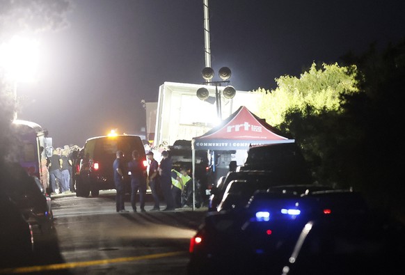 epaselect epa10037770 Police and officials man a roadblock near a tractor trailor on the side of the road leading to the location where more at least 46 migrants were reportedly found dead along with  ...
