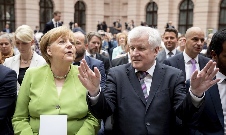 German Chancellor Angela Merkel, left, and Interior Minister Horst Seehofer attend an even to commemorate the victims of flight and expulsion in Berlin Wednesday, June 20, 2018. (Kay Nietfeld//dpa via ...