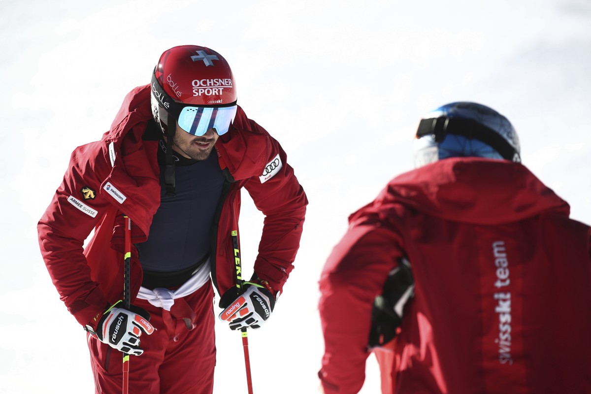 Switzerland's Loic Meillard, left, speaks to his teammate Marco Odermatt during an alpine ski, men's World Cup giant slalom, in Soelden, Austria, Sunday, Oct. 24, 2021. (AP Photo/Gabriele Fa ...