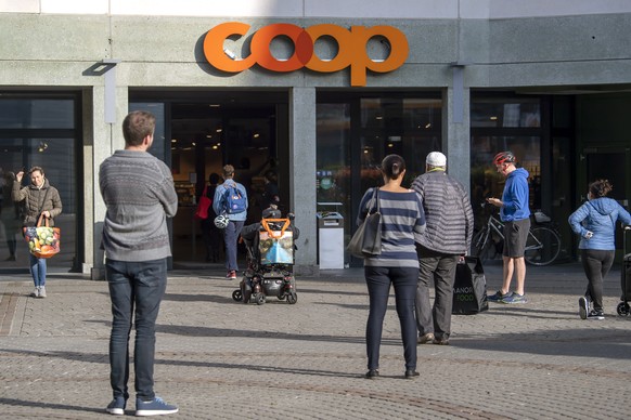Des clients d'un magasin d'alimentations (Coop) doivent desormais patienter avant de pouvoir faire leurs courses, ce samedi 21 mars 2020 a Geneve. Pour faire face aux nouvelles exigences san ...