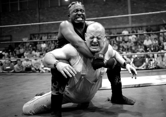 epa05916671 (09/32) Wrestler &#039;Big Fire&#039; (L) strangles his opponent &#039;Cowboy&#039; during a hardcore wrestling match at the Brakpan Community Hall, in Brakpan, Johannesburg, South Africa, ...