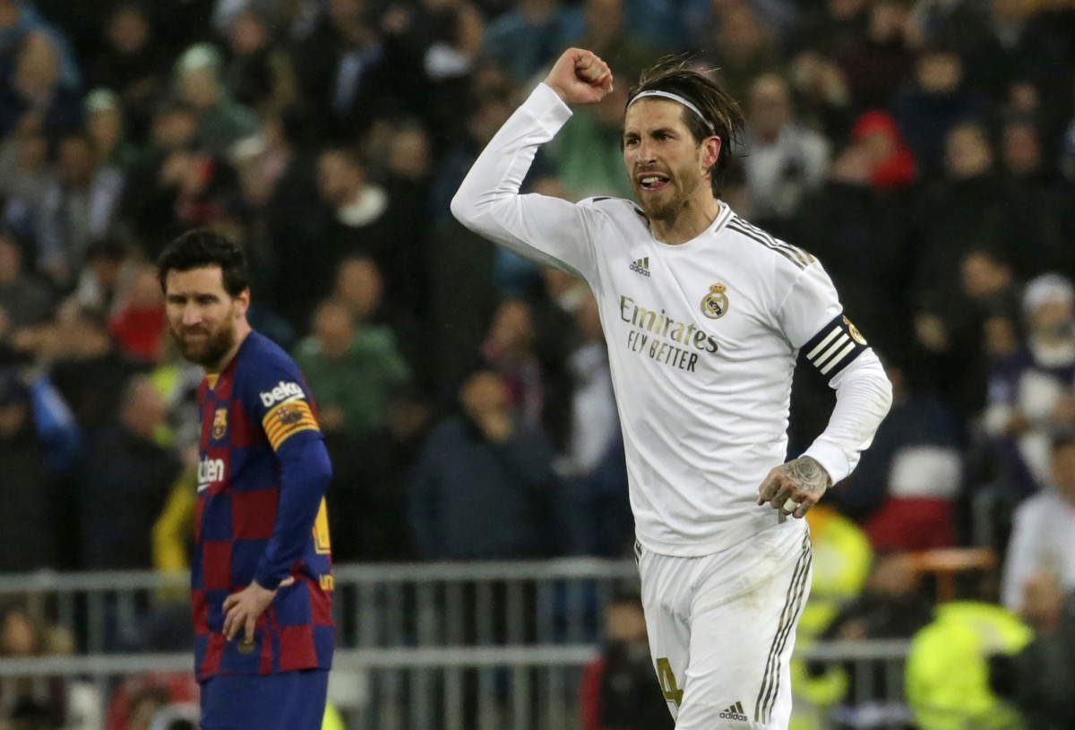 Real Madrid's Sergio Ramos celebrates as he runs past Barcelona's Lionel Messi during the Spanish La Liga soccer match between Real Madrid and Barcelona at the Santiago Bernabeu stadium in M ...