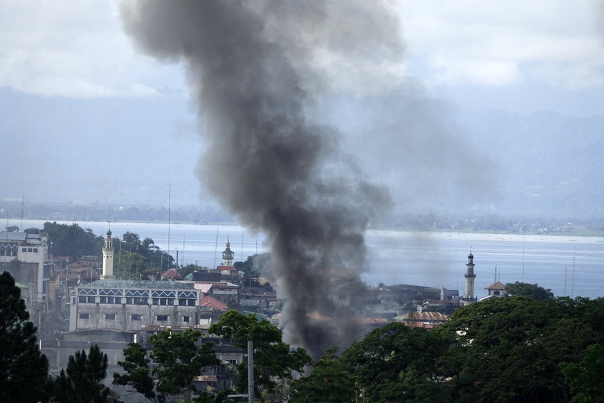 epa06002704 Smoke rises from a fire after an air strike inside the conflict area as fighting between Islamist militants and government forces continues in Marawi City, Mindanao Island, southern Philip ...