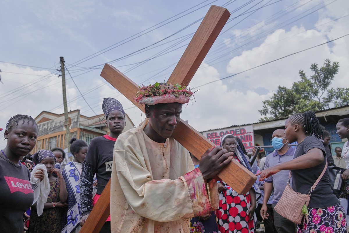 An actor portraying Jesus Christ carries a cross during a Way of the Cross reenactment during Easter Holy Week celebrations in the Kibera area of Nairobi, Kenya, Friday, April 18, 2025. (AP Photo/Bria ...
