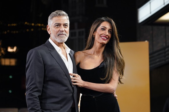 FILE - George Clooney and his wife Amal Clooney pose for photographers upon arrival at the screening of the film &quot;The Boys In The Boat,&quot; Dec. 3, 2023, in London. Amal Clooney is one of the l ...