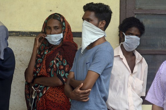 Indians standing in a queue outside a hospital wear masks as a precautionary measure against the Nipah virus at the Government Medical College hospital in Kozhikode, in the southern Indian state of Ke ...
