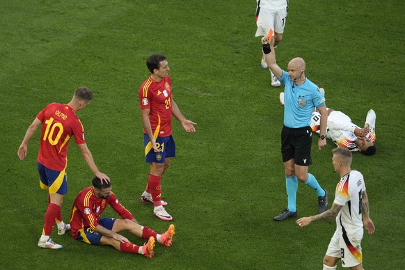 Spain&#039;s Dani Carvajal, 2nd left is shown a red card by the referee after commiting a tactical foul on Germany&#039;s Jamal Musiala during a quarter final match between Germany and Spain at the Eu ...