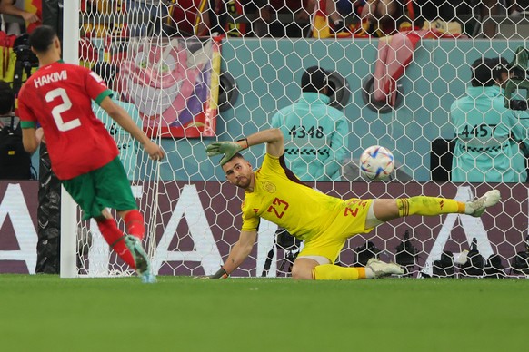 epa10352372 Achraf Hakimi (L) of Morocco converts the decisive penalty against goalkeeper Unai Simon of Spain during the penalty shoot-out of the FIFA World Cup 2022 round of 16 soccer match between M ...
