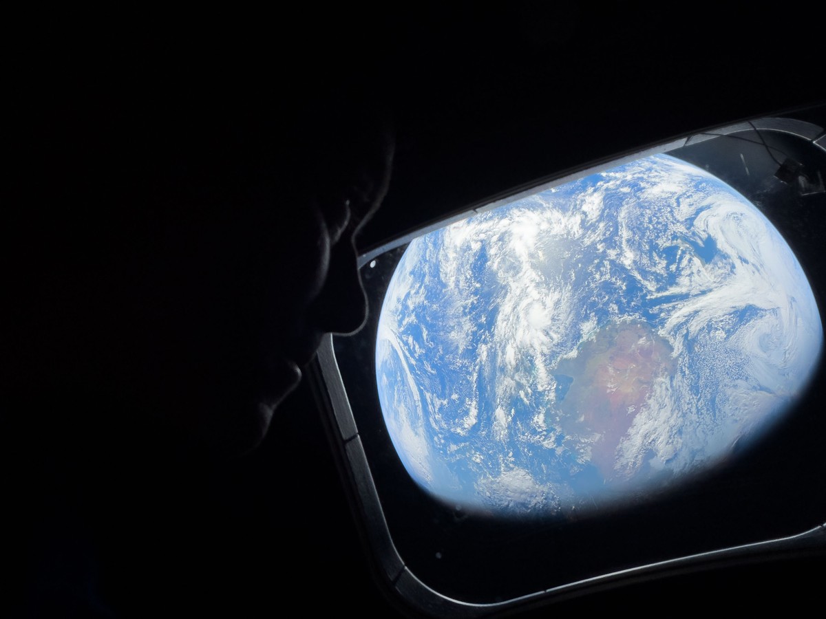 In this photo provided by NASA, Commander Reid Wiseman looks at the Earth from a window aboard the Orion spacecraft Integrity during the Artemis II mission en route to the moon on Thursday, April 2, 2 ...
