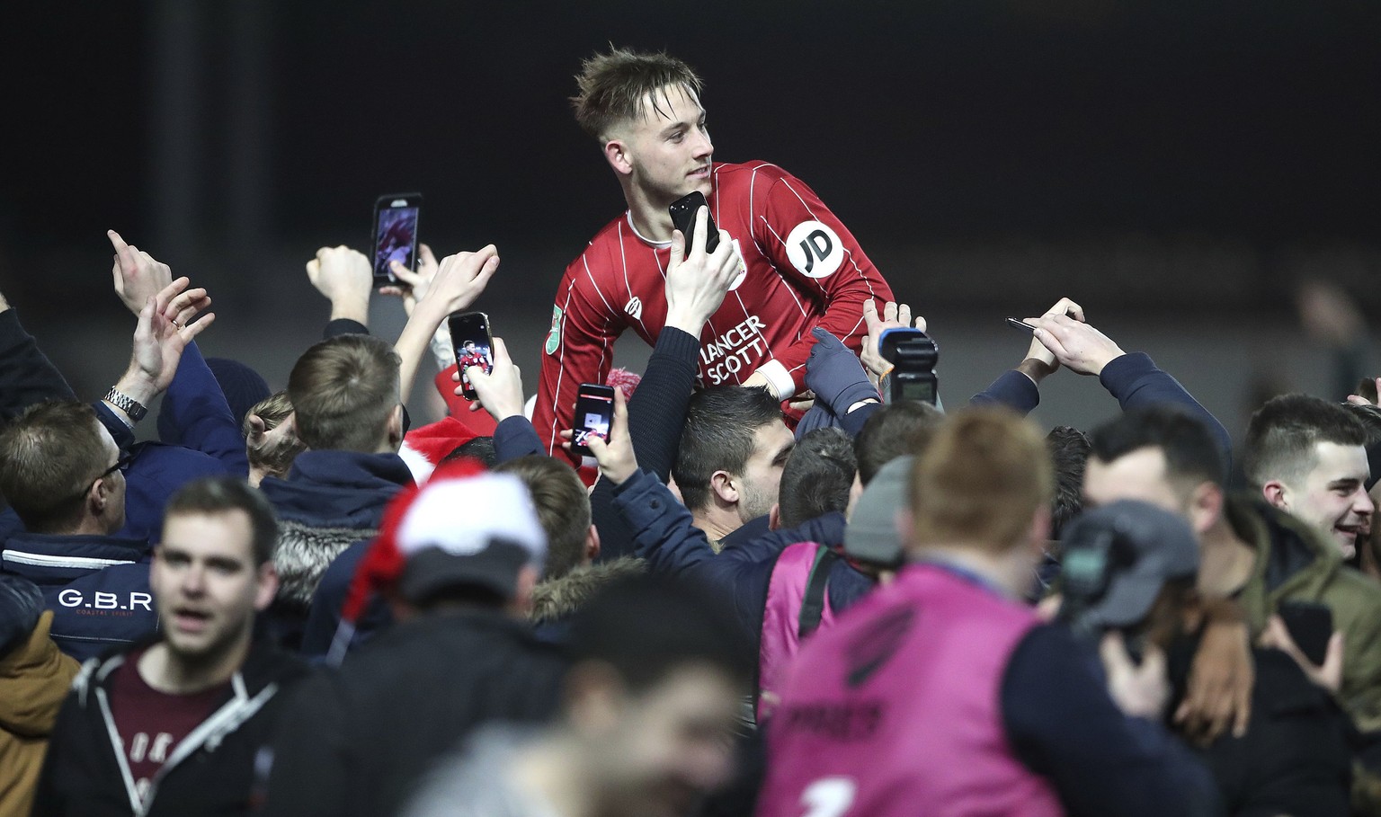 Bristol City&#039;s Josh Brownhill celebrates their victory as he is lifted up by fans after the final whistle in the English League Cup Quarter Final soccer match between Bristol City and Manchester  ...