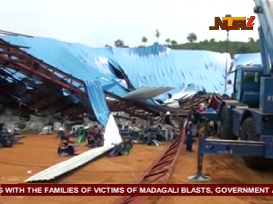 People stand near the remains of a church which collapsed during a service in the southern city of Uyo in Akwa Ibom state, Nigeria in this still image from video December 10, 2016. Video taken Decembe ...