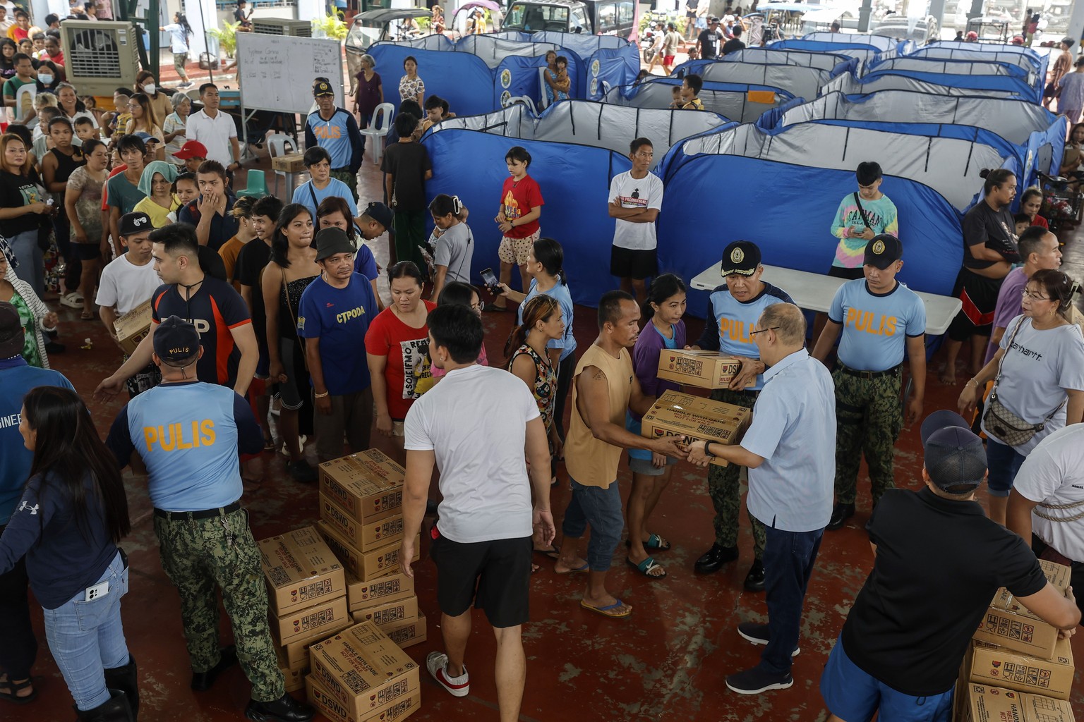 epa11495323 Families affected by flood receive boxes of relief supplies at a school used as an evacuation center in Marikina City, Metro Manila, Philippines, 25 July 2024. A state of calamity was decl ...