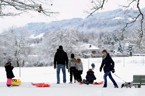 Spaziergaenger und Familien freuen sich im frisch gefallenen Schnee wieder einmal ueber weisse Weihnachten am Samstag, 25 Dezember 2010, in einem Aussenquartier in Bern. (KEYSTONE/Lukas Lehmann)