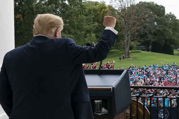 President Donald Trump pumps his fist to the crowd with a bandages on his hand, before speaking from the Blue Room Balcony of the White House to a crowd of supporters, Saturday, Oct. 10, 2020, in Wash ...